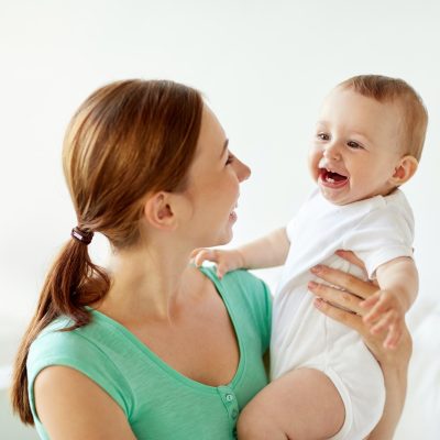 happy young mother with little baby at home